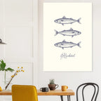 Framed artwork of fish illustrations on a wall above a table with decor items.