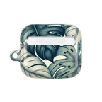 An open, empty AirPods Pro case, showcasing a stylish tropical monstera leaf pattern in a cool-toned palette of deep blue and off-white.