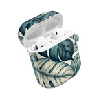 A stylish, open AirPods charging case with a custom monstera leaf design, highlighting the earbuds ready for use. The case features a two-tone color palette of deep marine and soft ivory.