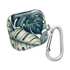 Protective case for AirPods Pro, featuring a bold, graphic monstera leaf print and a large matte silver carabiner clip. The closed case has a striking color contrast of dark forest green and a pale creamy white.