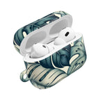 AirPods Pro case with a tropical leaf pattern, featuring large, stylized green and cream monstera leaves. The case is open, revealing the white AirPods Pro with their black speaker grilles.