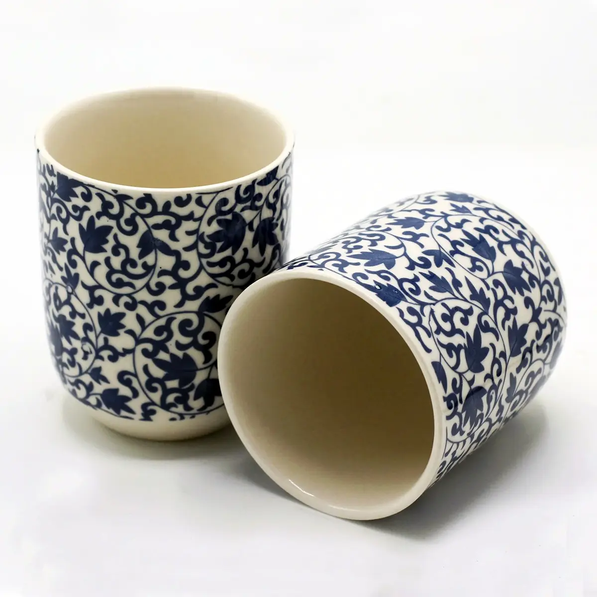 Two ceramic cups with blue floral patterns on a white background