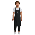 Child wearing a black apron with 'Archie' printed on it against a white background