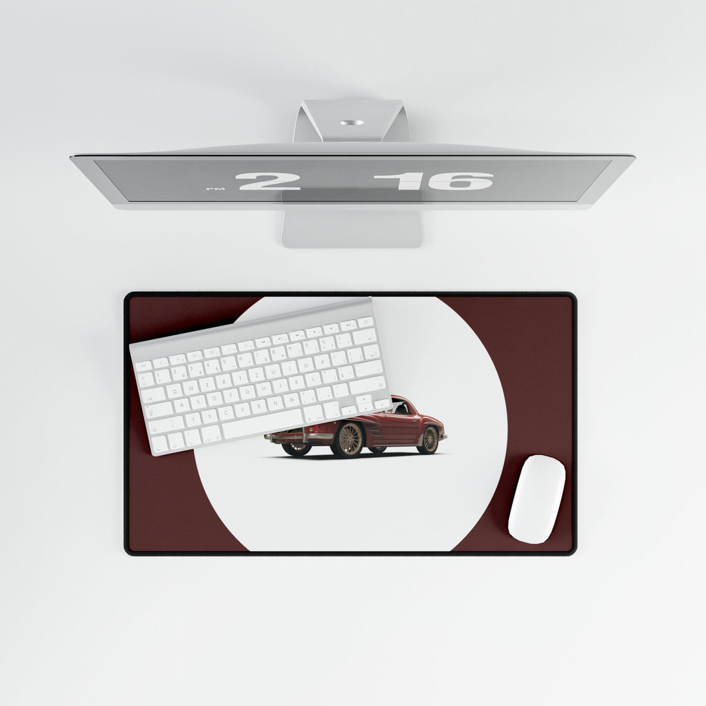 Desk setup with a monitor, keyboard, mouse, and car model on a desk pad.