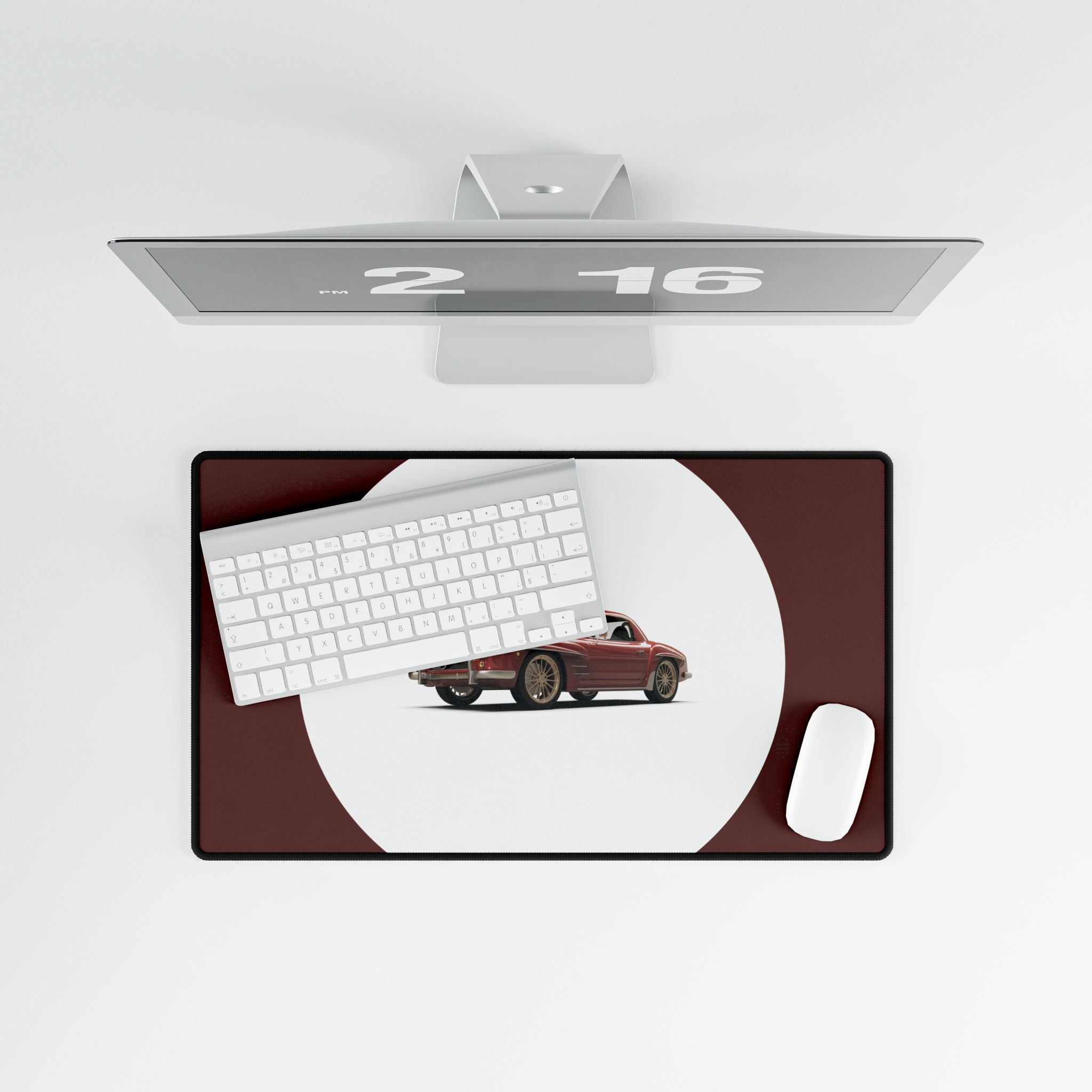 Desk setup with a monitor, keyboard, mouse, and car model on a desk pad.