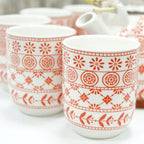 Two white mugs with red geometric patterns on a white background from MVB STUDIO official store.
