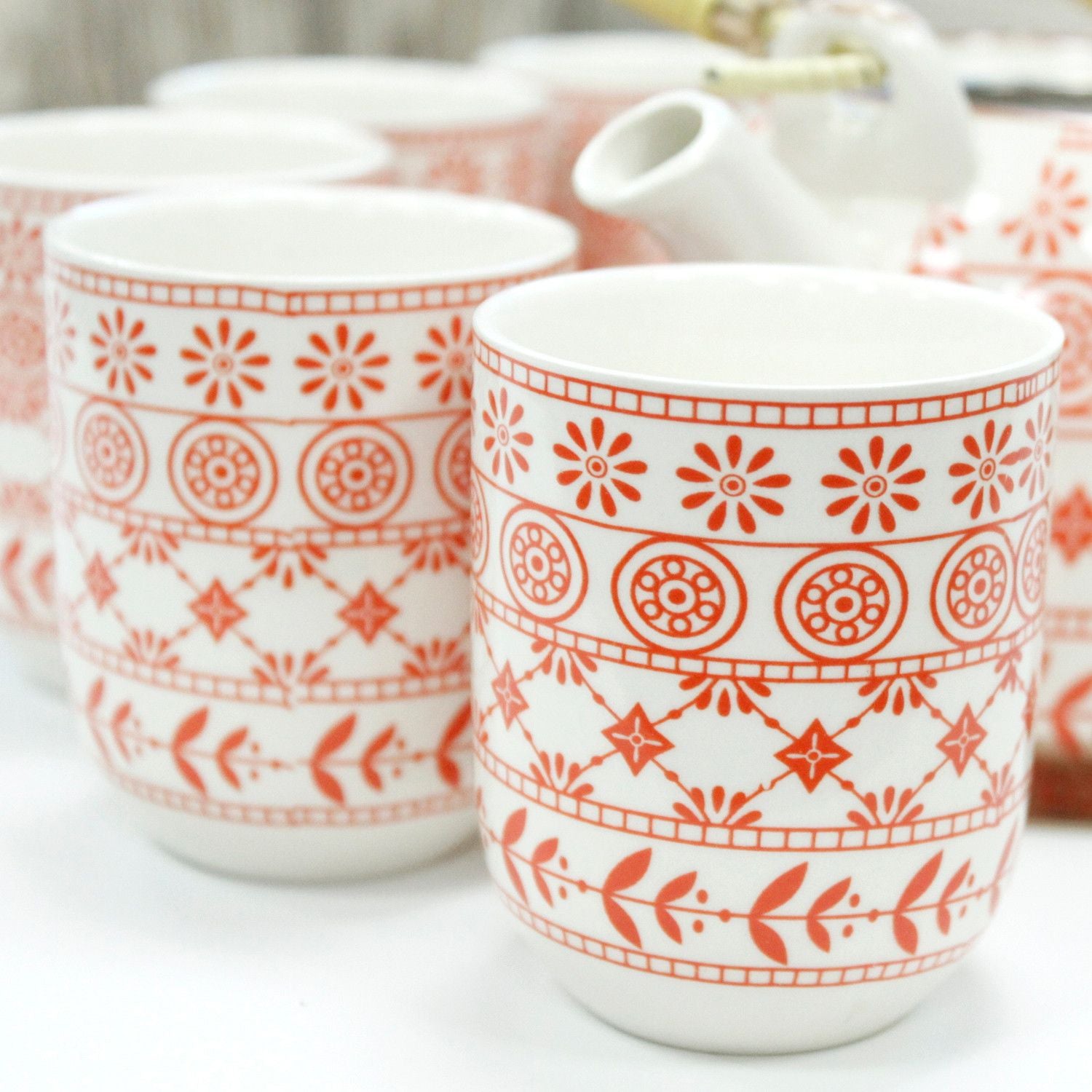 Two white mugs with red geometric patterns on a white background from MVB STUDIO official store.