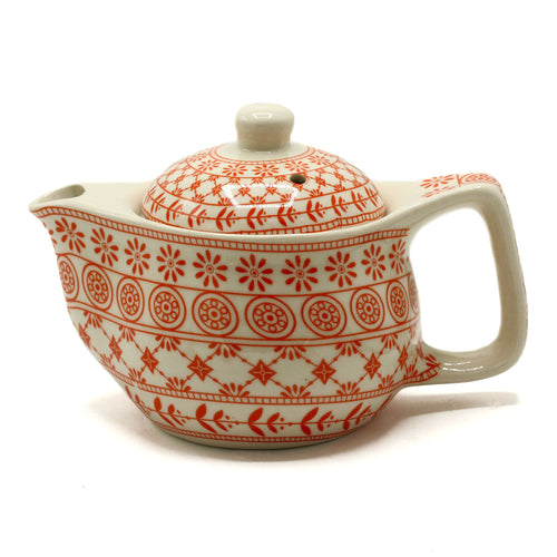 Ceramic teapot with red patterns on a white background