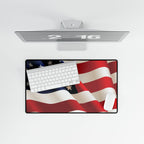 Desk setup with a computer monitor, keyboard, and mouse pad featuring an American flag design on a white background.