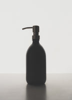 Black soap dispenser on a white background