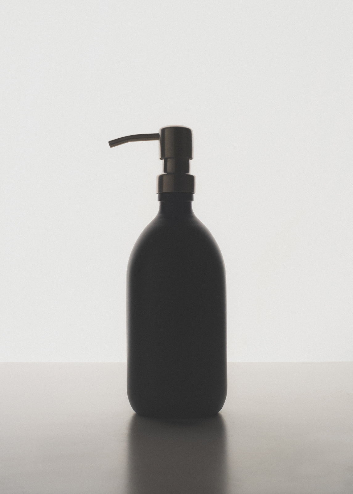 Black soap dispenser on a white background