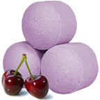 Three purple bath bombs with two cherries on a white background