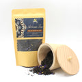 Artisan Black Tea Earl Grey Mauve - 50g package with an open wooden container on a white background