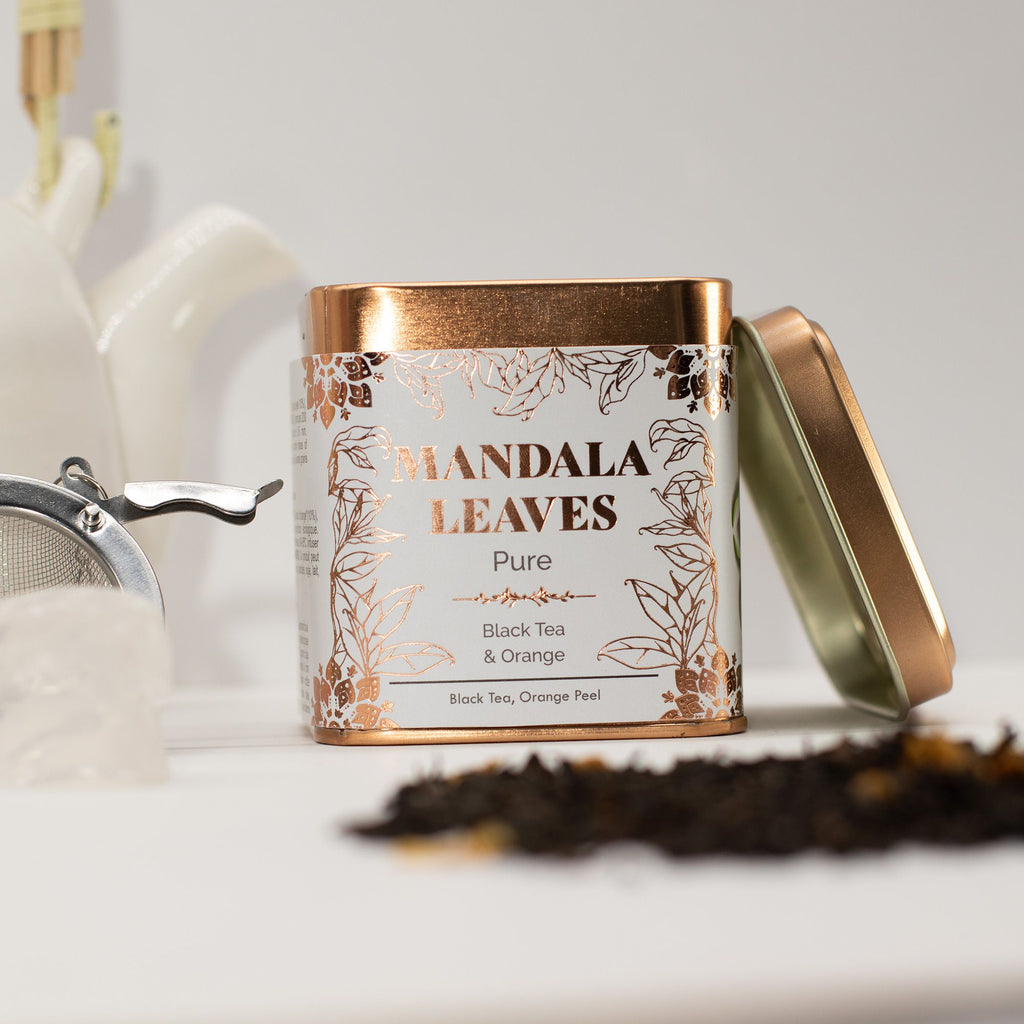 Mandala Leaves tea canister with loose tea on a white surface