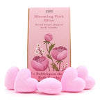 Pink heart-shaped bath bombs with a 'Blooming Pink Bliss' packaging on a white background