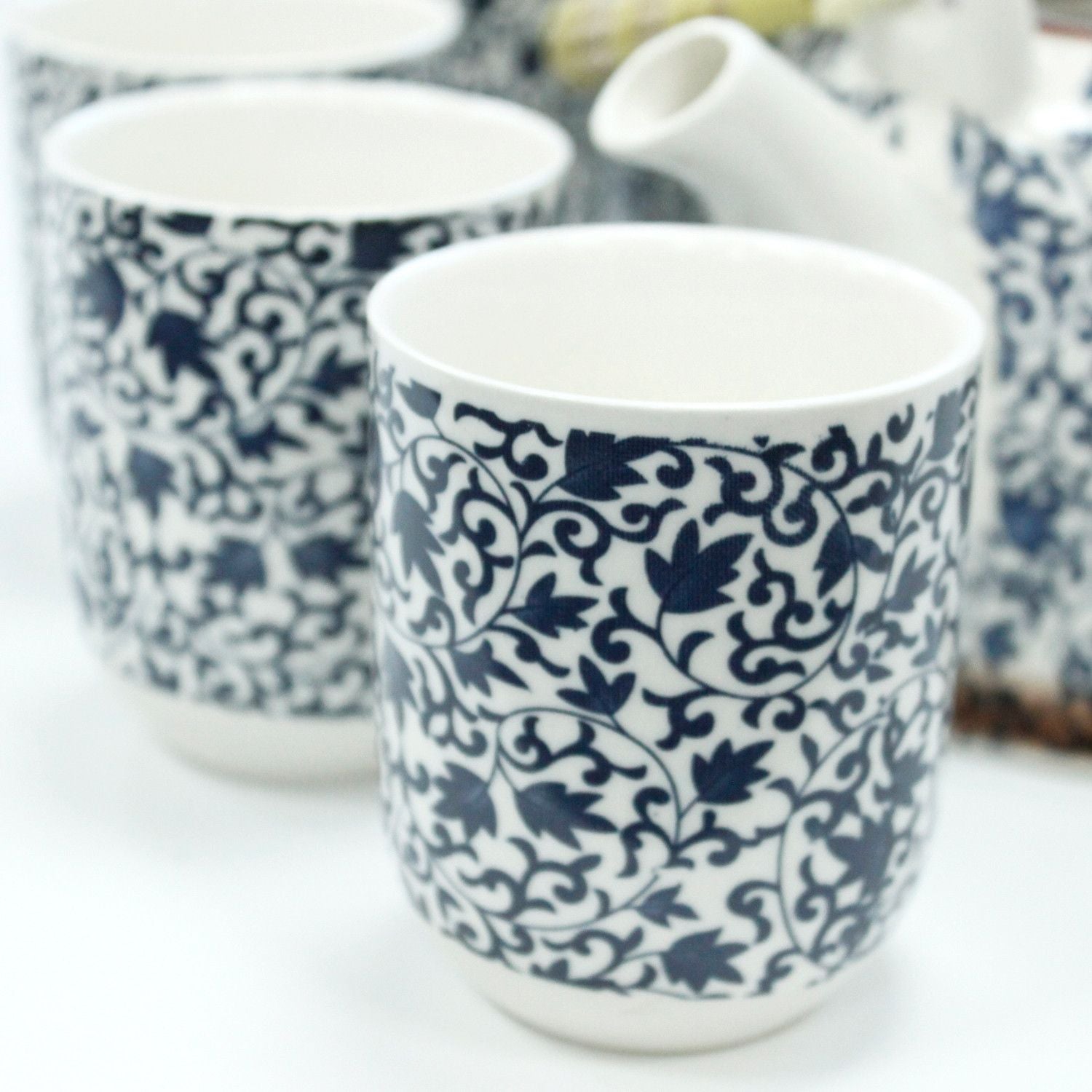 Ceramic cups with blue floral patterns on a white background