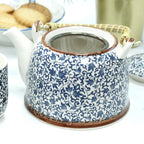 Ceramic teapot with blue floral pattern on a white background