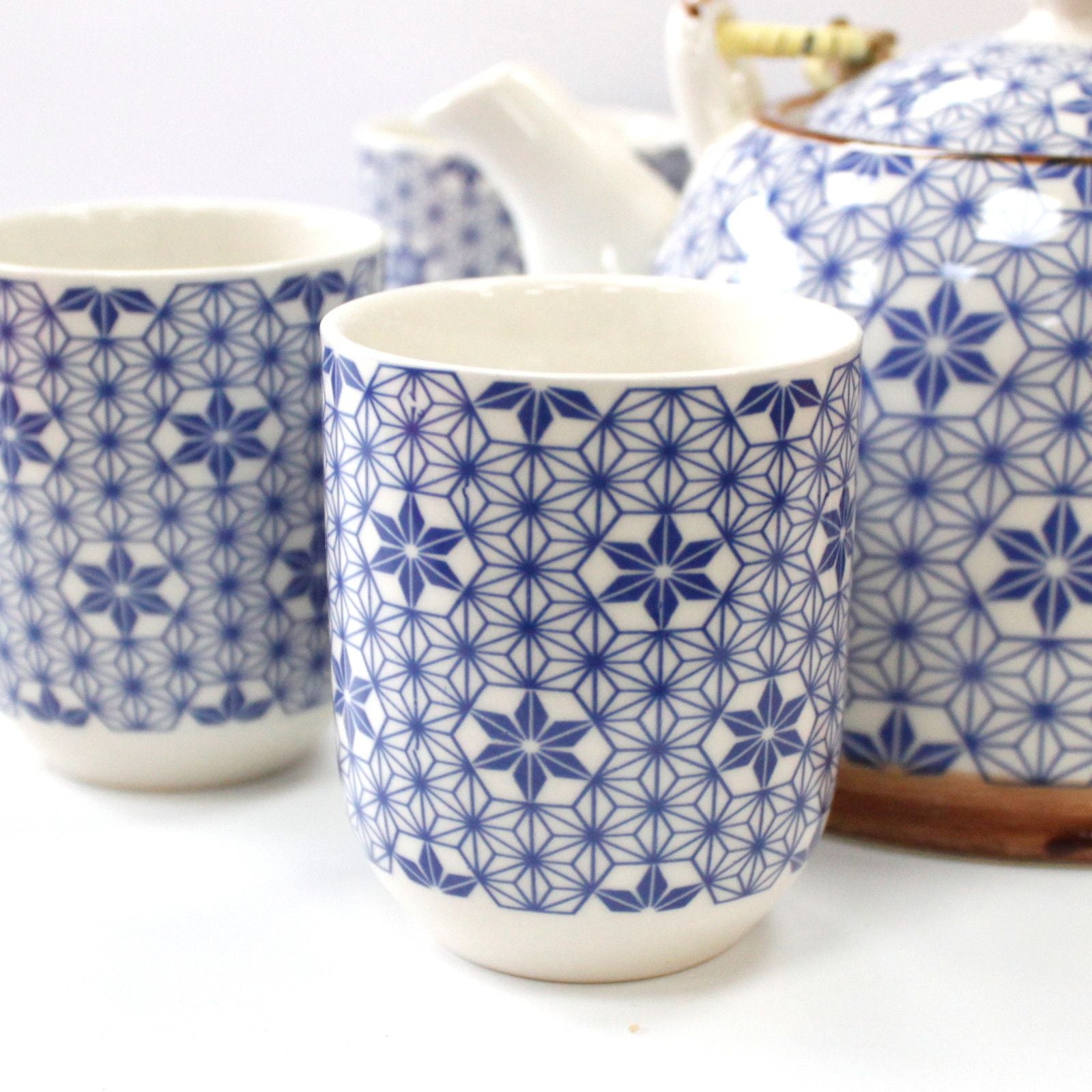 Ceramic cups with blue geometric pattern on a white background.
