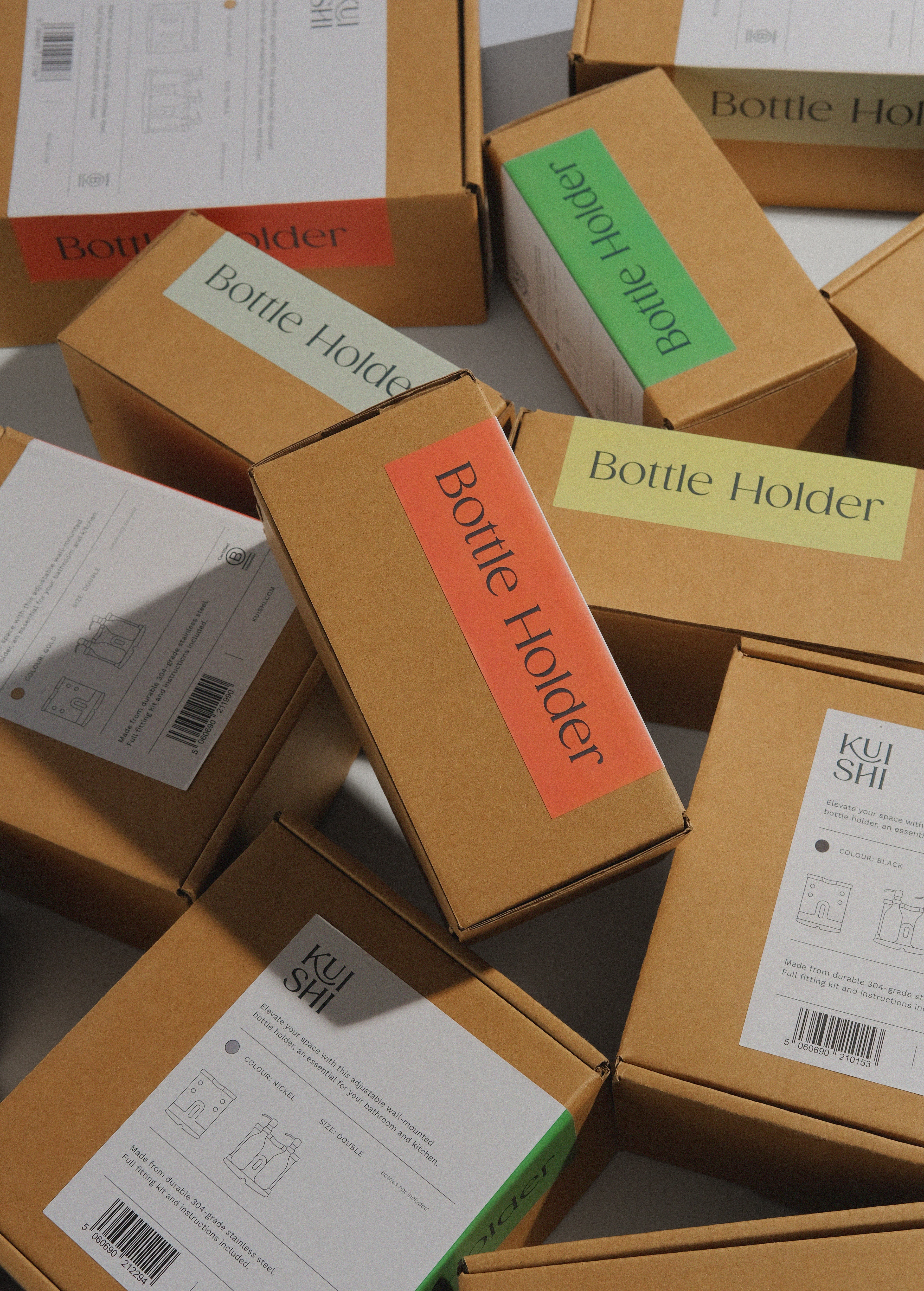 Stack of cardboard boxes labeled 'Bottle Holder' on a gray surface