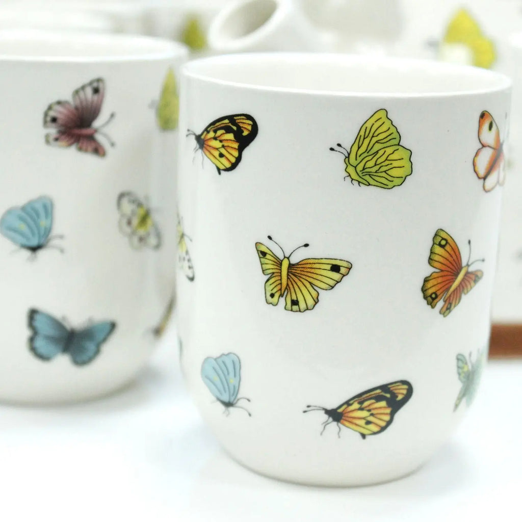 Ceramic mug with colorful butterfly designs on a white background