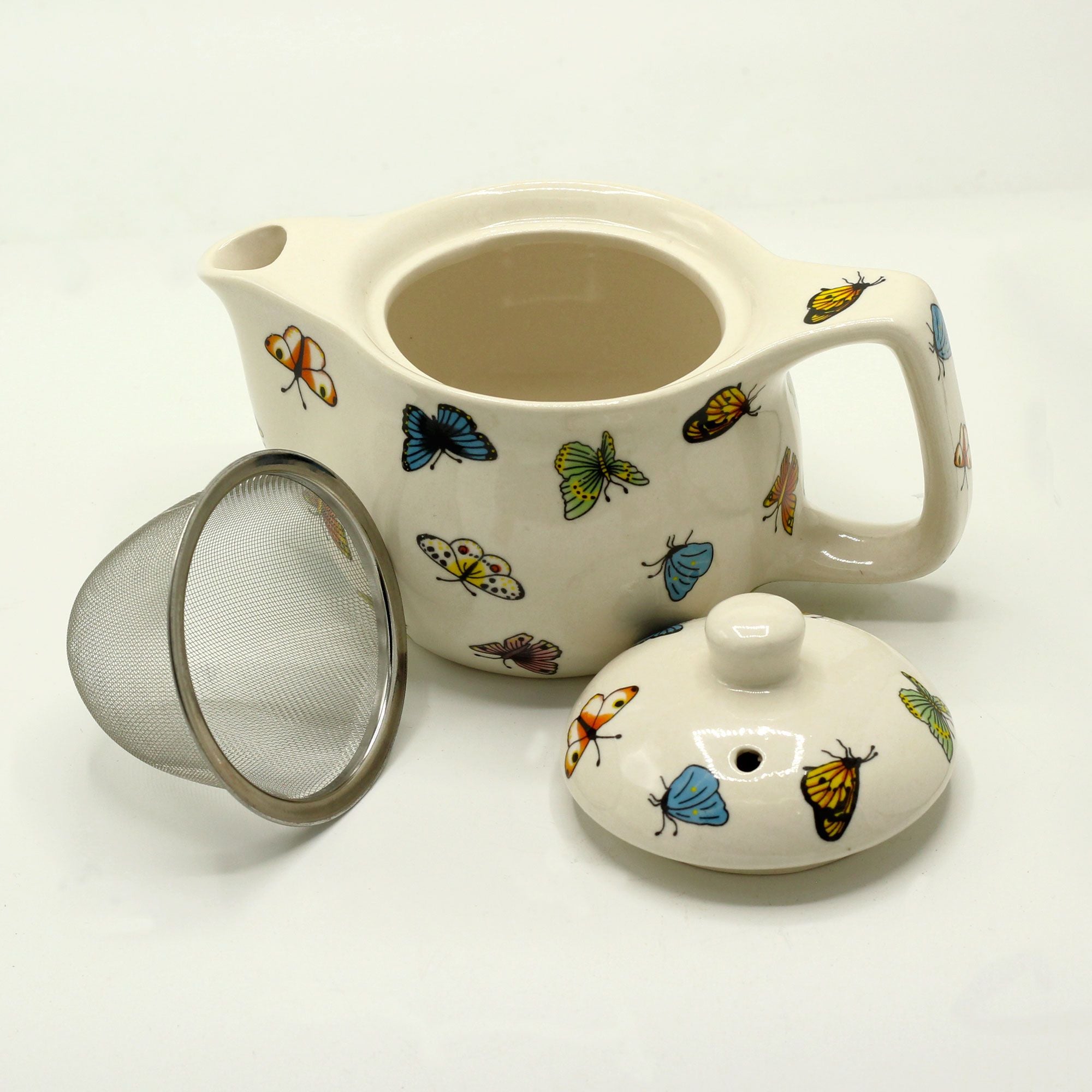 Ceramic teapot with butterfly designs on a white background