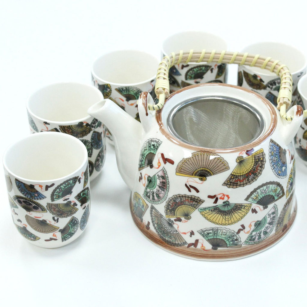 Ceramic teapot and cups with fan pattern on a white background