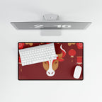 Desk setup with a monitor, keyboard, mouse, and decorative mouse pad featuring a cow design on a red background.