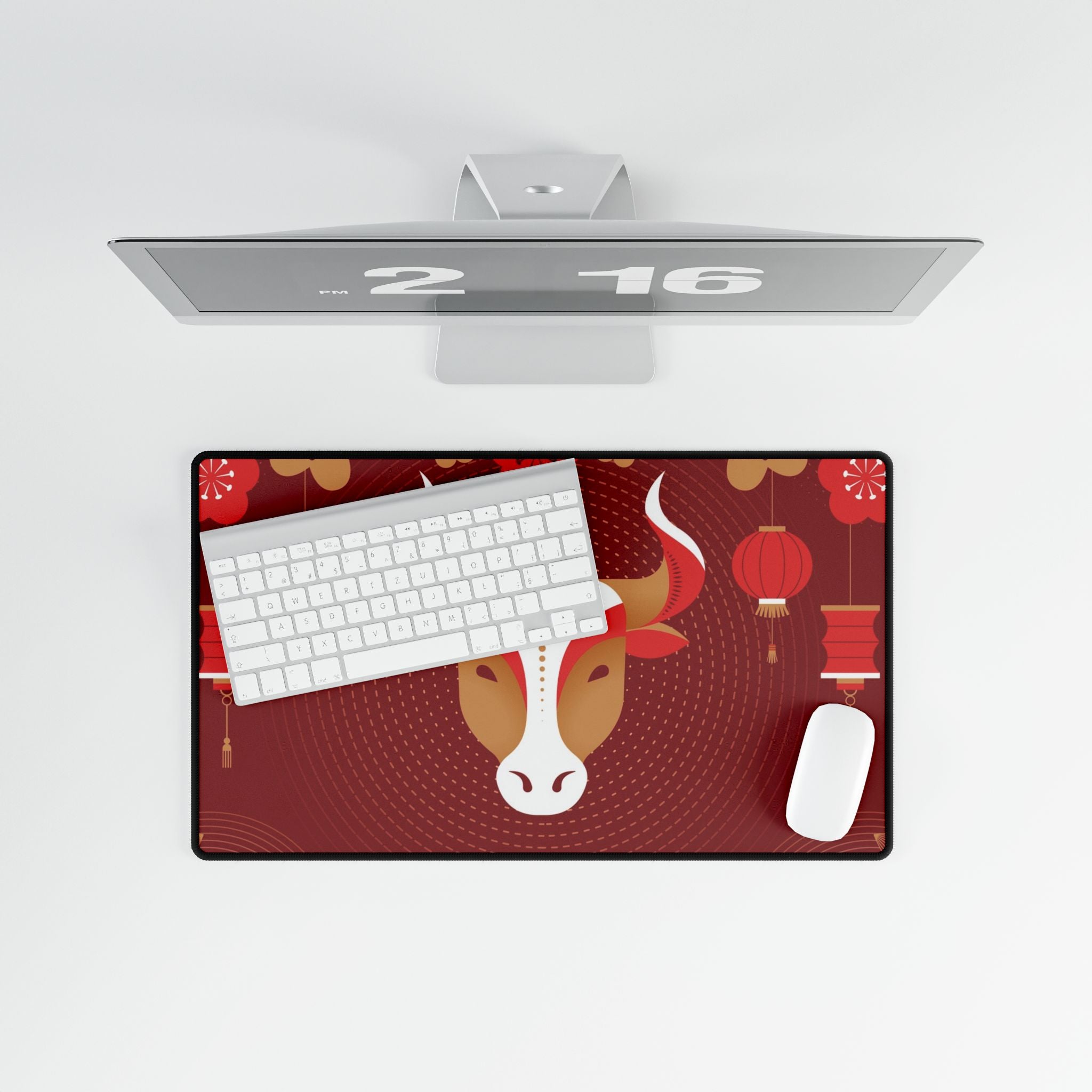 Desk setup with a monitor, keyboard, mouse, and decorative mouse pad featuring a cow design on a red background.