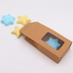 Star-shaped blue and yellow bath bombs with a cardboard box on a white background