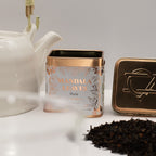 Tea canister labelled 'Mandala Leaves' Cinnamon Black Tea 50g with a teapot and tea leaves on a light surface.