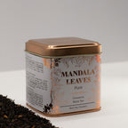 Tea tin labeled 'Mandala Leaves Pure'  Cinnamon Black Tea 50g with a copper lid on a white background