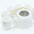 White ceramic teapot with metal mesh lid and six matching cups on a white background