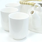 Set of white ceramic tea cups and a teapot on a white background
