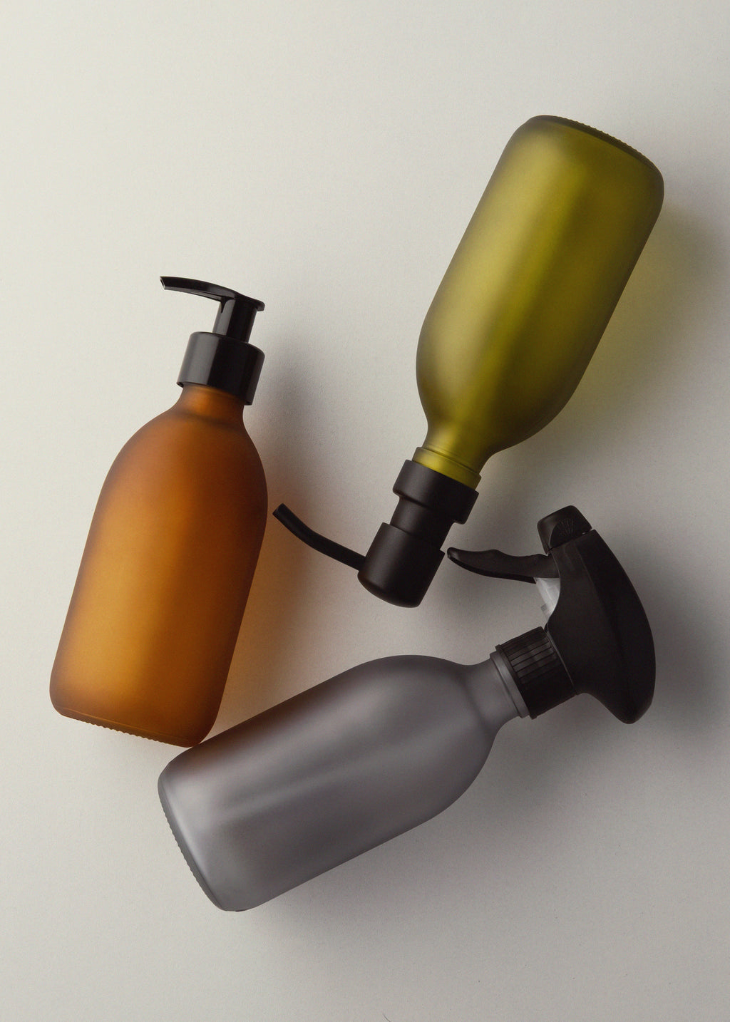 Three bottles with different designs on a light background