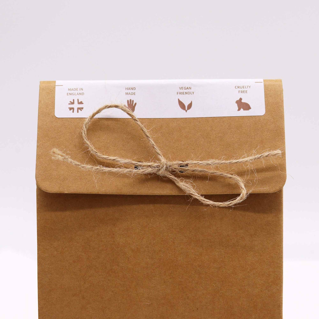 Brown paper package with string bow and a label on a white background
