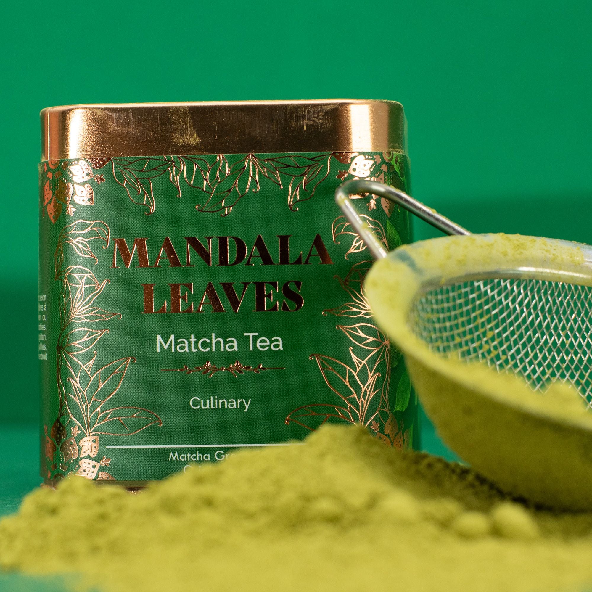 Mandala Leaves Matcha Tea can with green tea powder and a mesh spoon on a green background