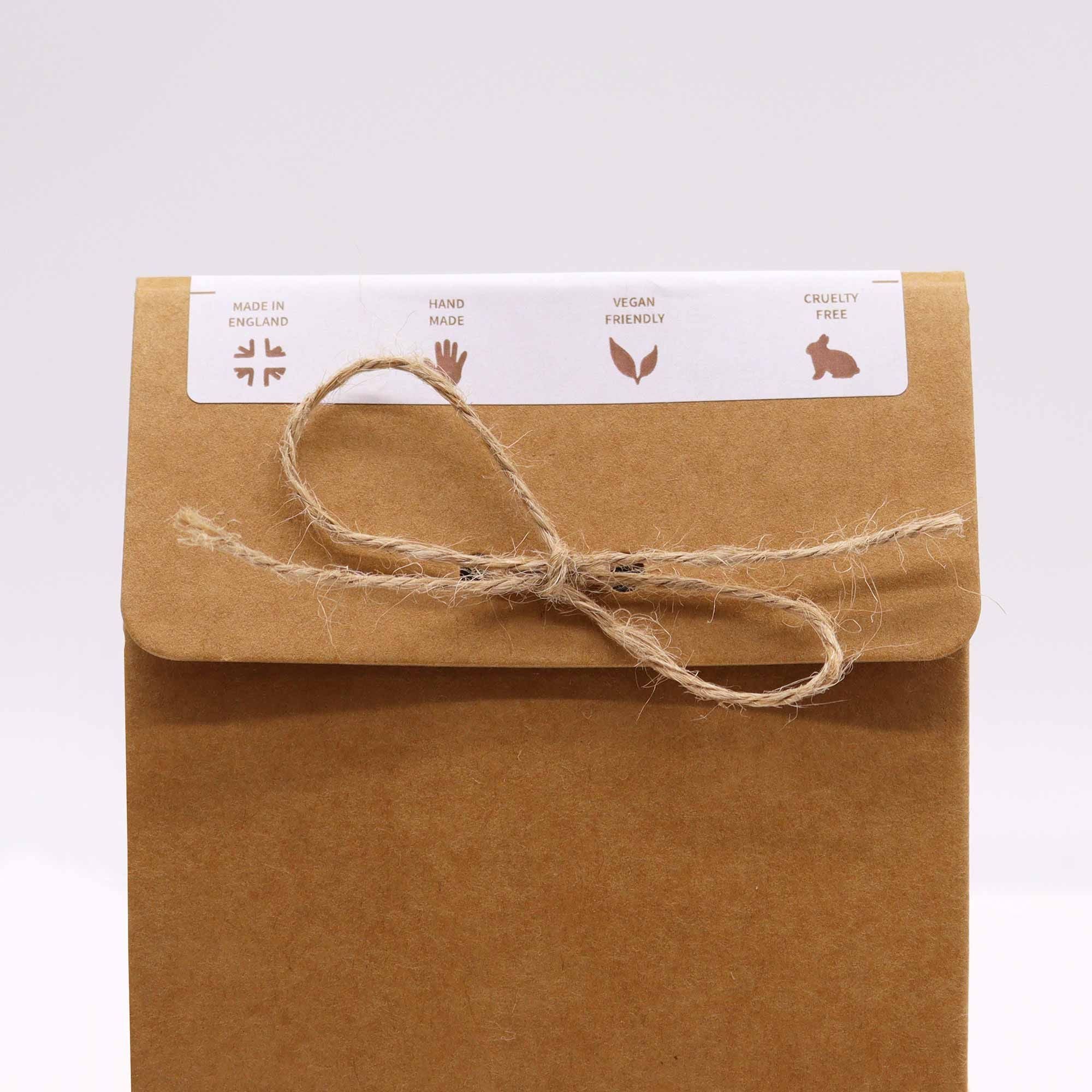 Brown paper package with string bow and a label on a white background