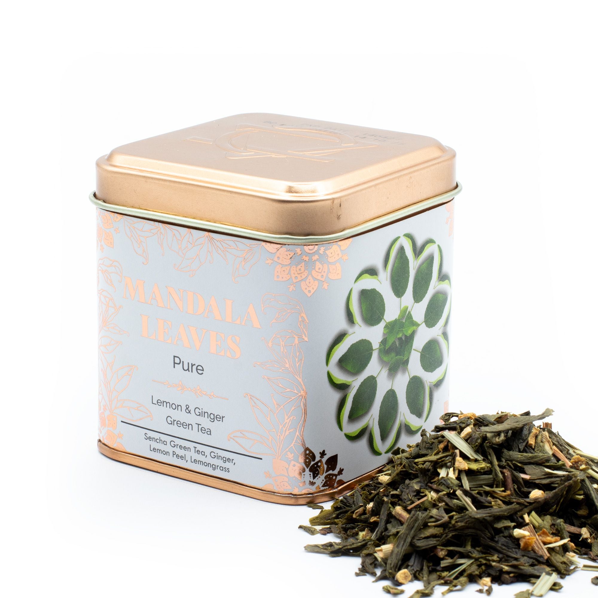 Tea tin labeled 'Mandala Leaves' with Ginger & Lemon Green Tea Sencha Blend 50g spilling out on a white background