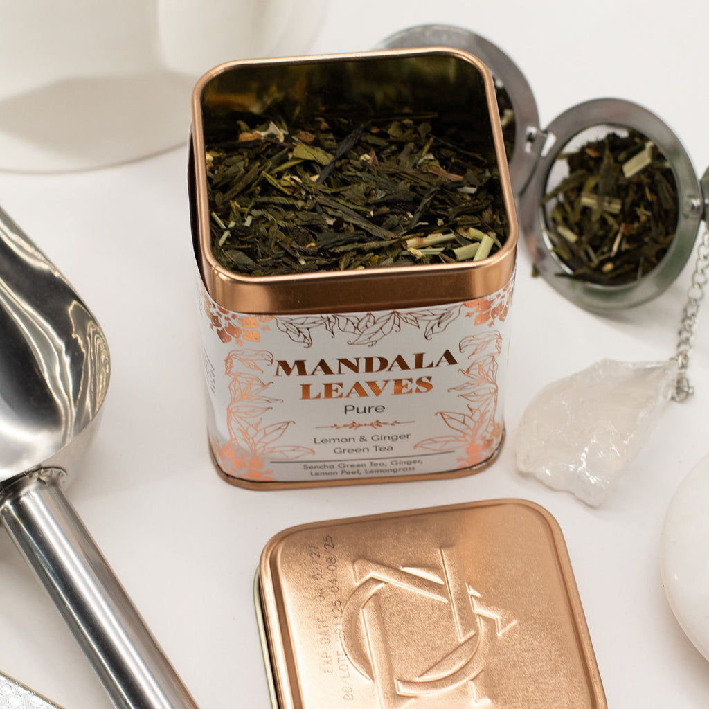 Tea tin labeled 'Mandala Leaves' with Ginger & Lemon Green Tea Sencha Blend 50g and a tea scoop on a white surface.