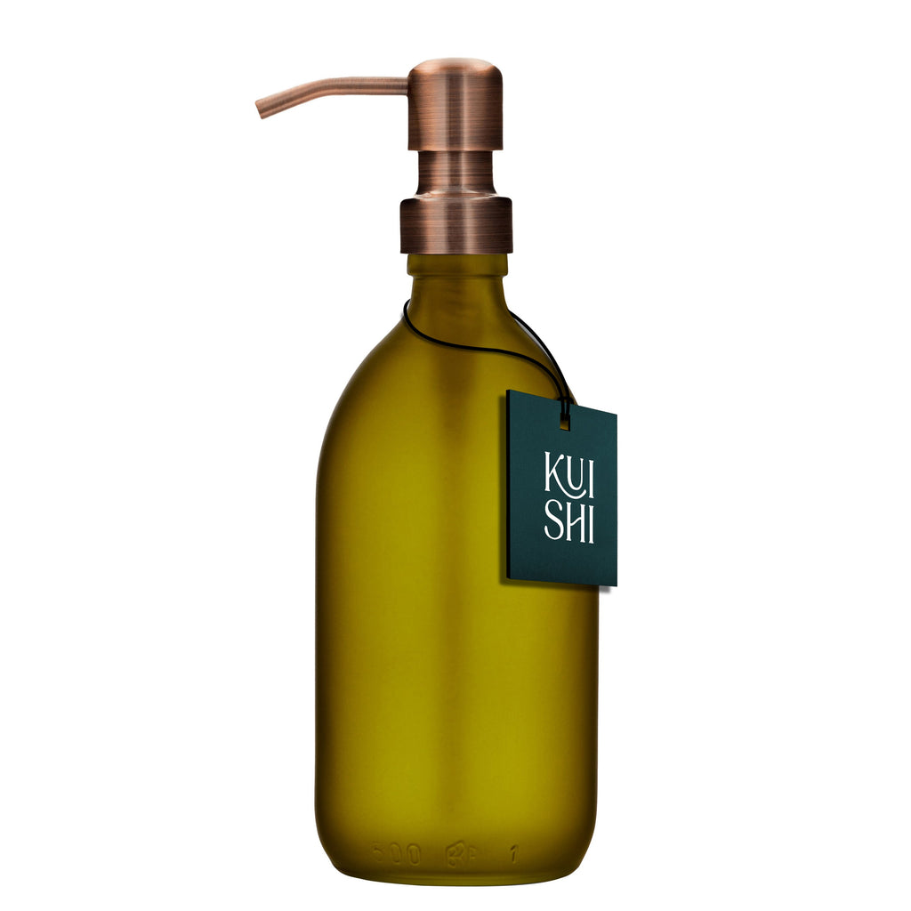Green soap dispenser bottle with copper pump and 'Kushi' tag on a white background