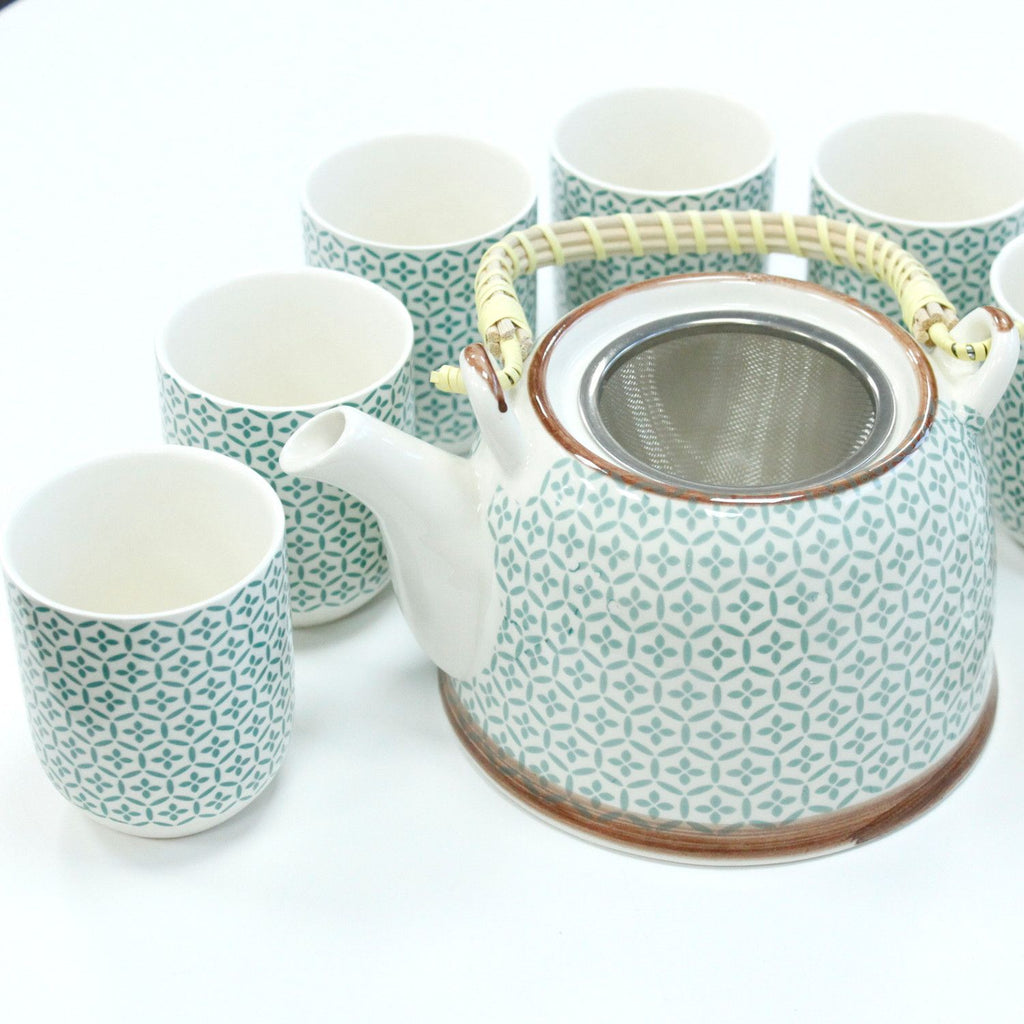 Ceramic teapot and cups with geometric pattern on a white background