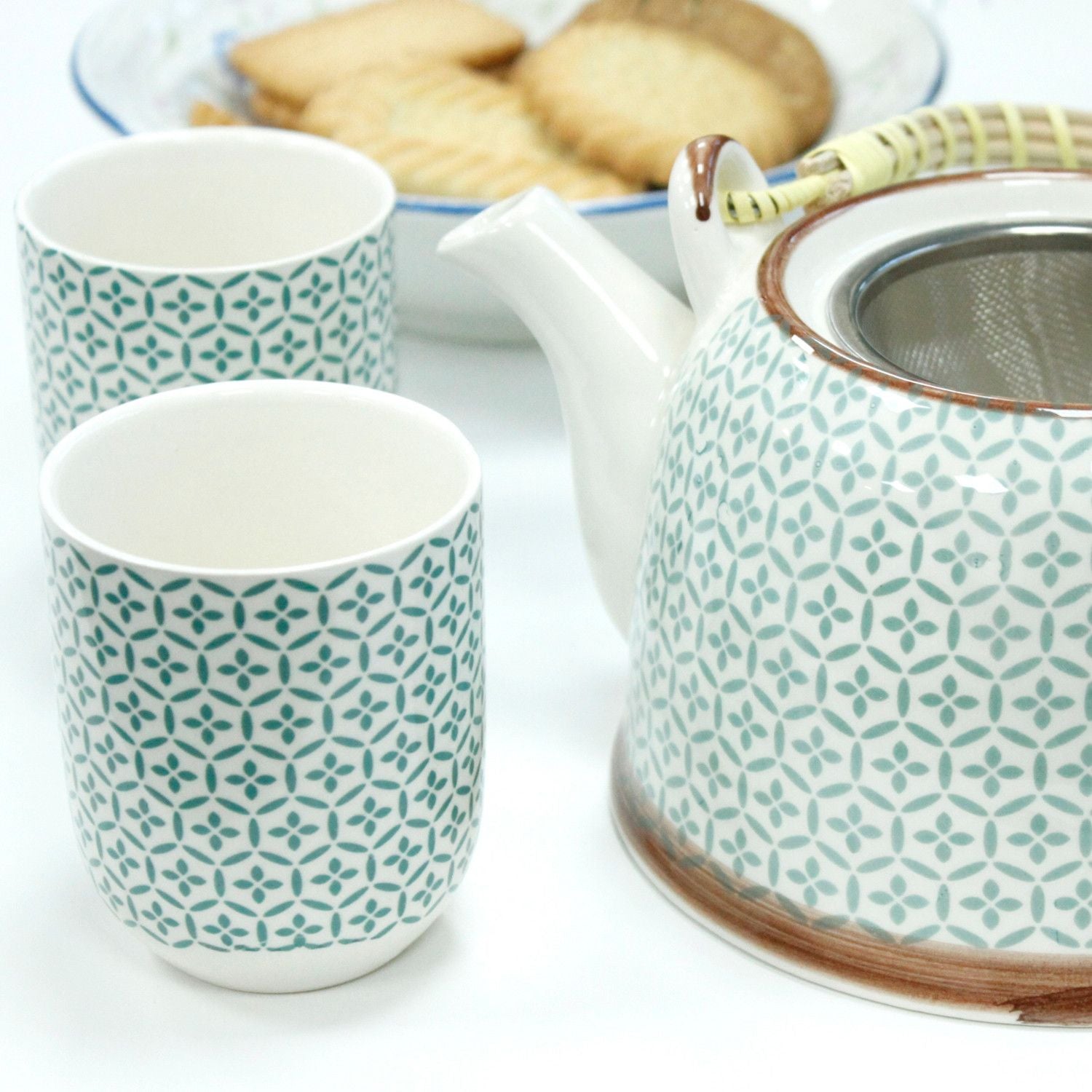Ceramic teapot and mugs with geometric pattern on a white background