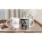 Two mugs on a table with one featuring a floral design and the other with a photo of a woman, placed against a neutral background.