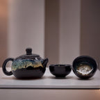 Ceramic teapot and two cups on a light surface with a neutral background