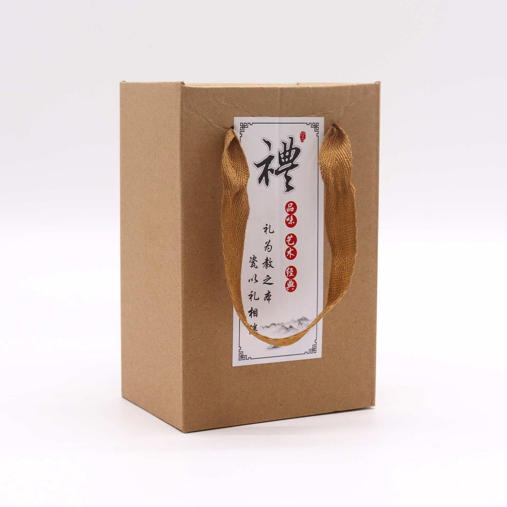 Brown paper gift box with a handle and a label on a white background