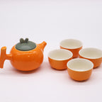 Ceramic teapot and four cups on a white background