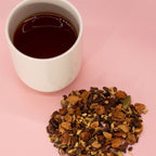 White cup of black tea with a Hot Chocolate Chai Infusion - 50g on a pink background