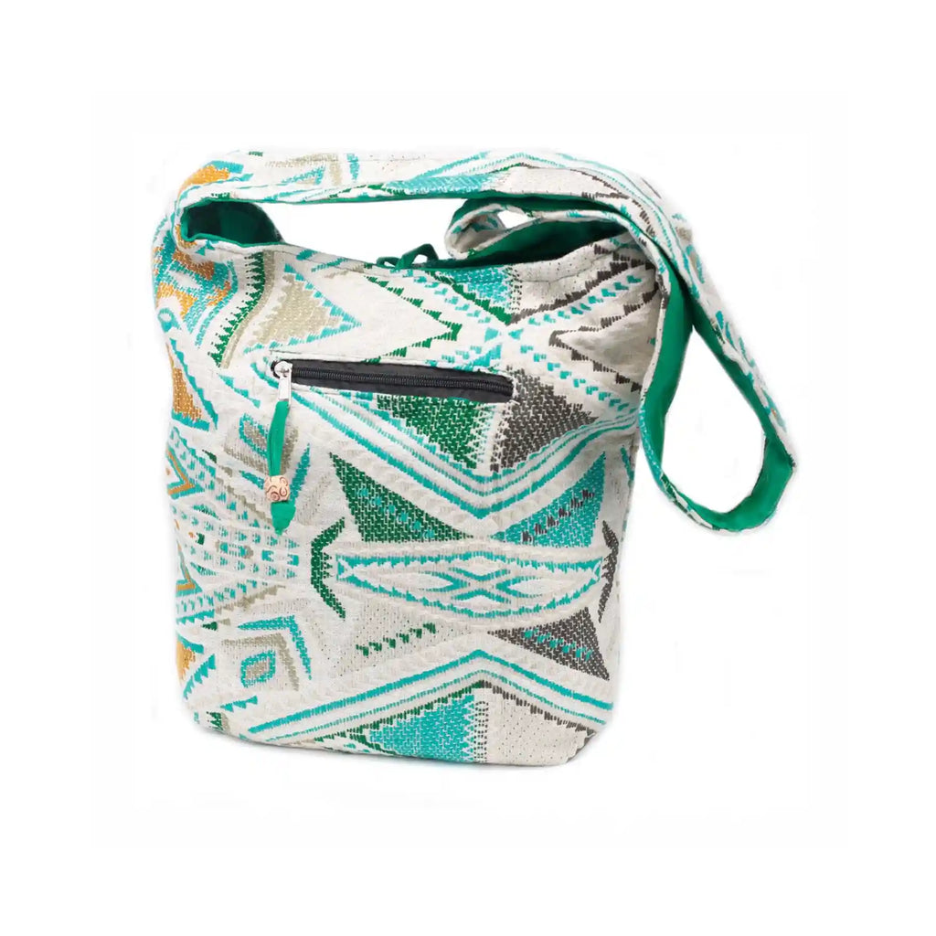 Patterned shoulder bag with a green strap on a white background