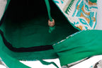 Close-up of a green drawstring bag with a decorative pattern on a white background