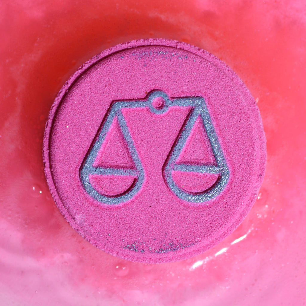 Pink bath bomb with Libra zodiac symbol on a pink background